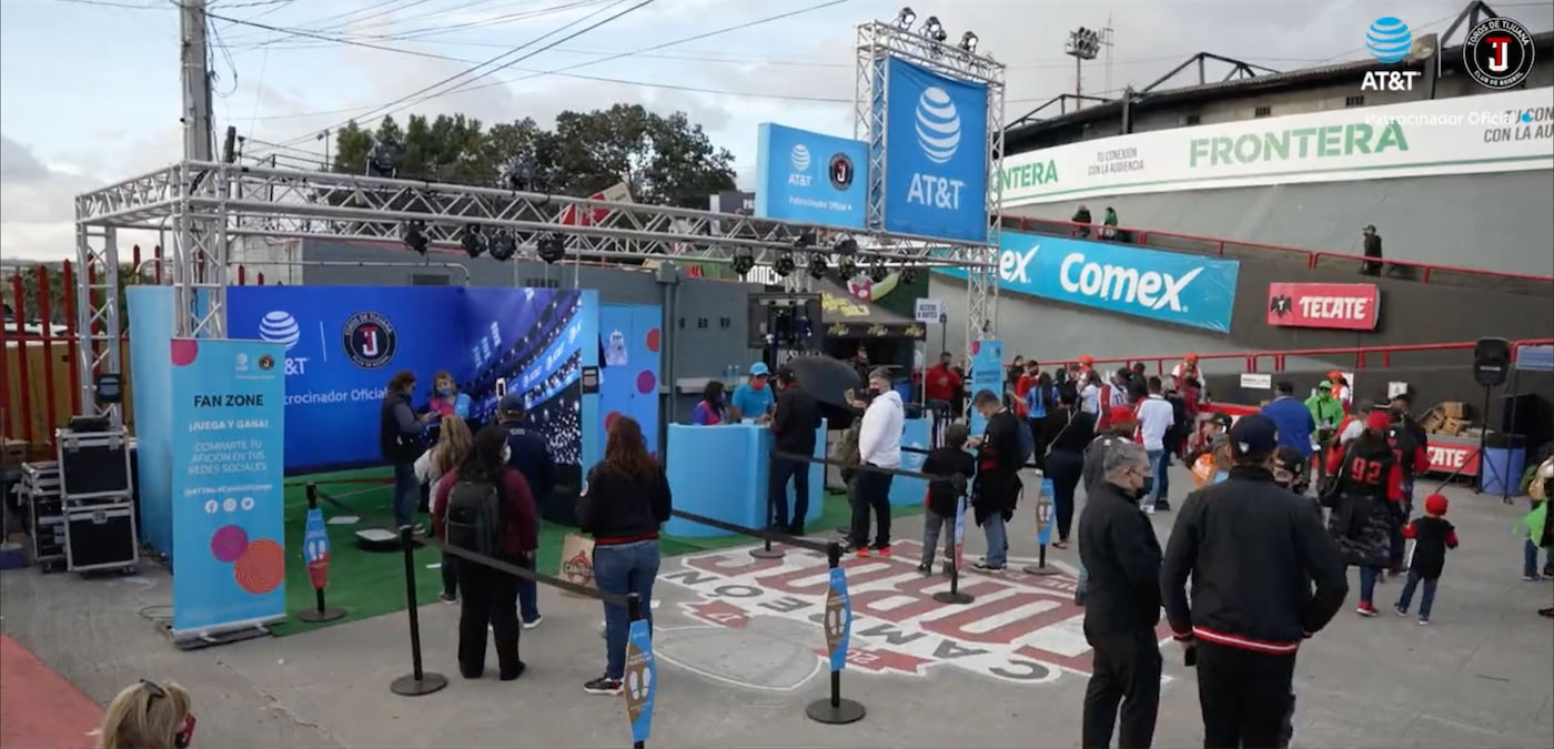 Gente caminando y visitando stands de marcas en estadio de baseball