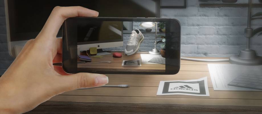 Telefono que ve un marcador de realidad aumentada en un escritorio y muestra un zapato en 3D flotando encima
